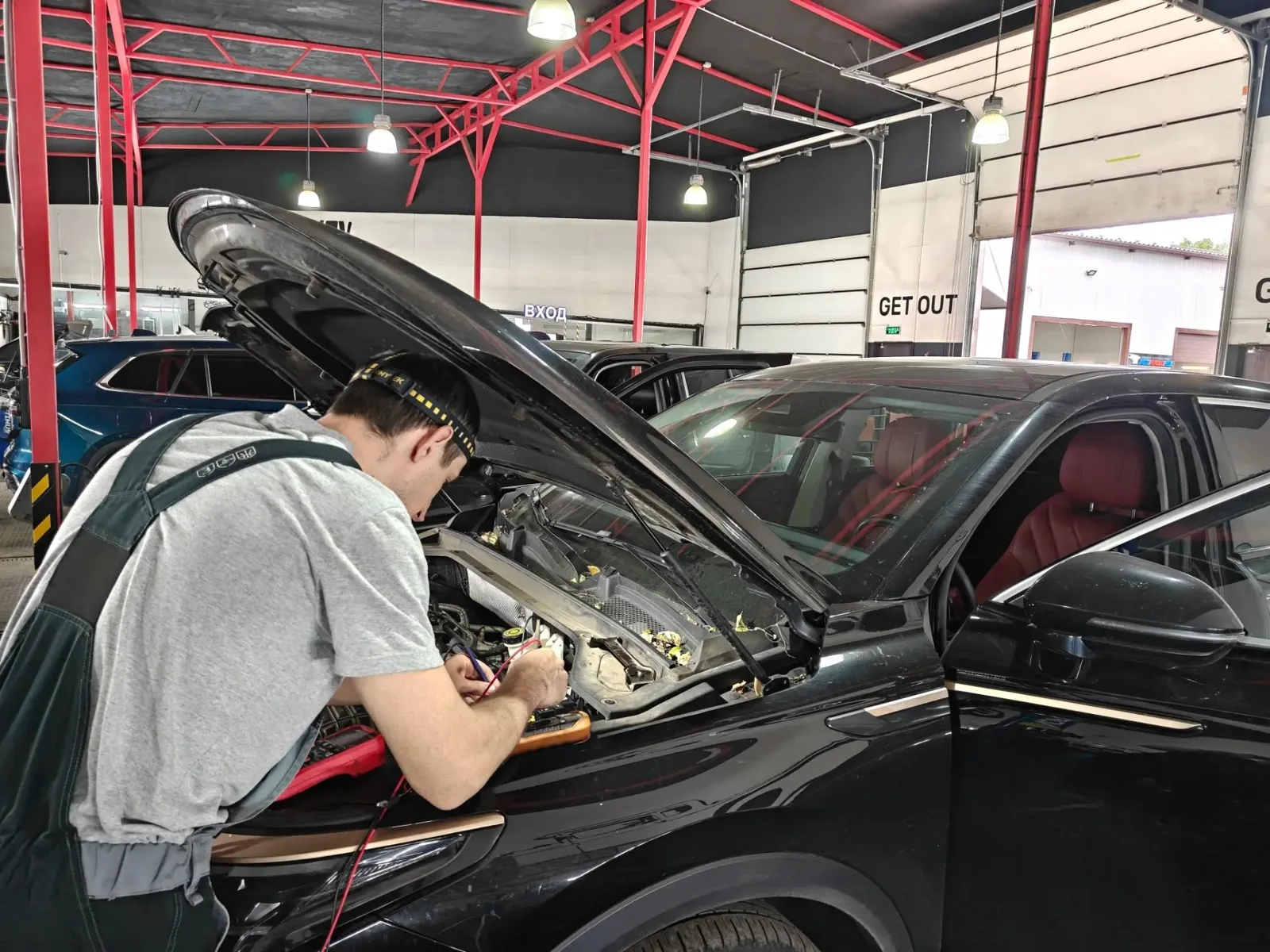 Специалист работает под капотом автомобиля